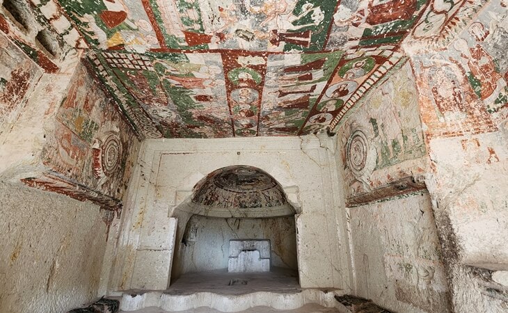 Pancarlık Kilisesi’nin iç mekanı; renkli İncil sahneli freskler ve kaya oyma mimari detaylar